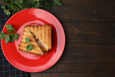 Pieces of toasted bread with melted cheese and parsley on wooden table, flat lay. Space for text