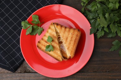 Photo of Pieces of toasted bread with melted cheese and parsley on wooden table, flat lay