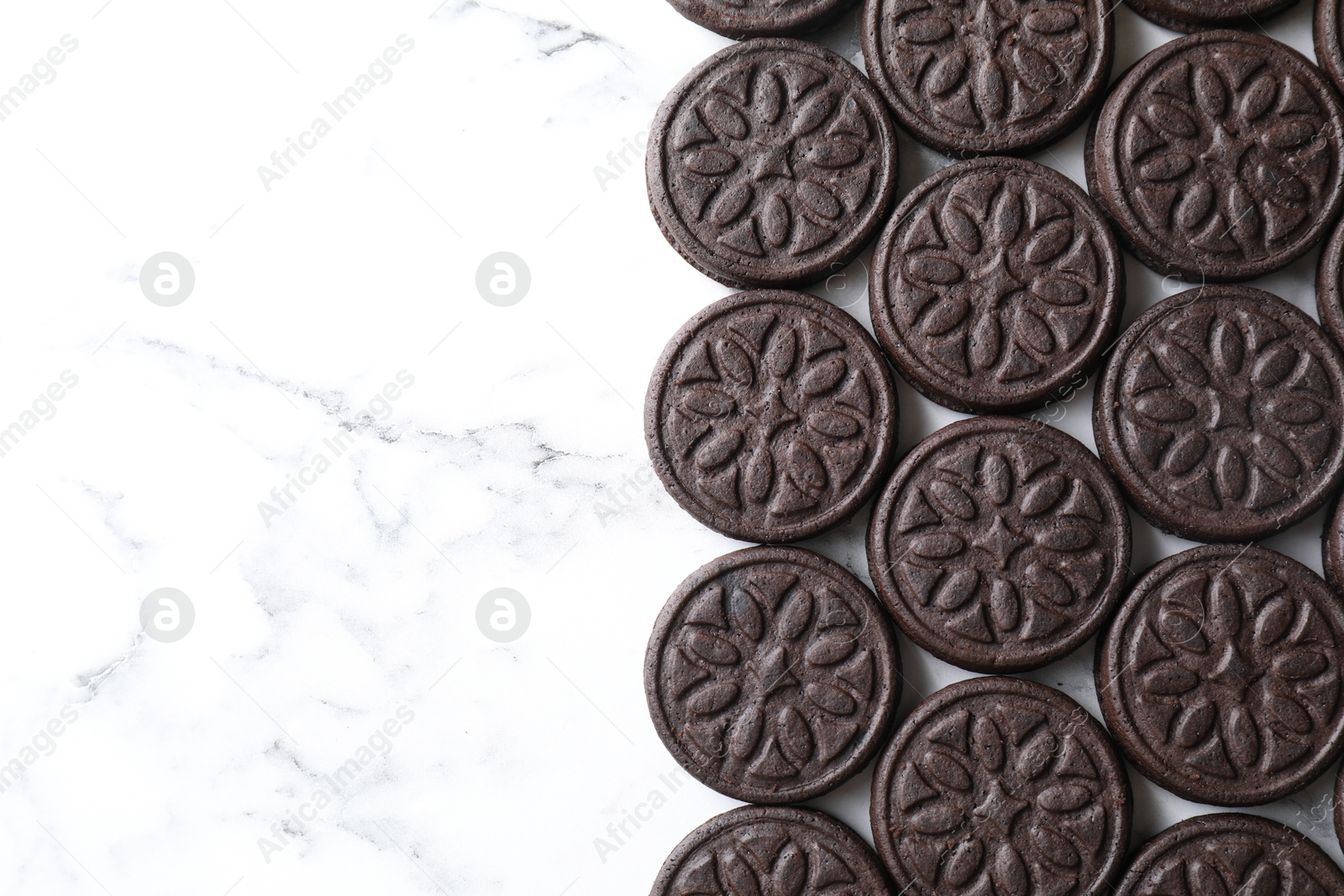 Photo of Tasty sandwich cookies on white marble table, top view. Space for text