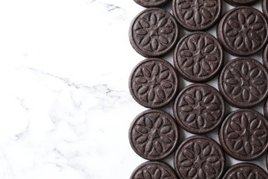 Photo of Tasty sandwich cookies on white marble table, top view. Space for text