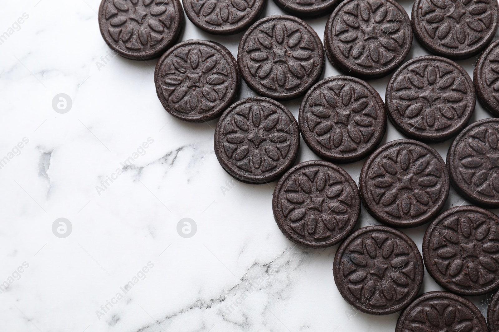 Photo of Tasty sandwich cookies on white marble table, top view. Space for text