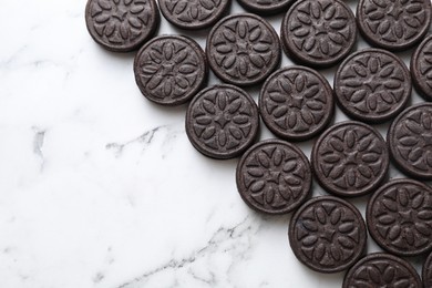 Tasty sandwich cookies on white marble table, top view. Space for text