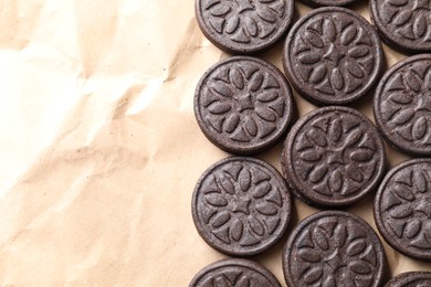 Photo of Tasty sandwich cookies on parchment paper, top view. Space for text