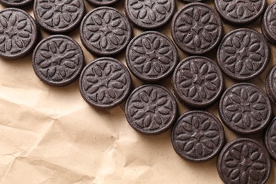 Tasty sandwich cookies on parchment paper, top view