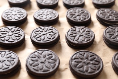 Many tasty sandwich cookies on parchment paper