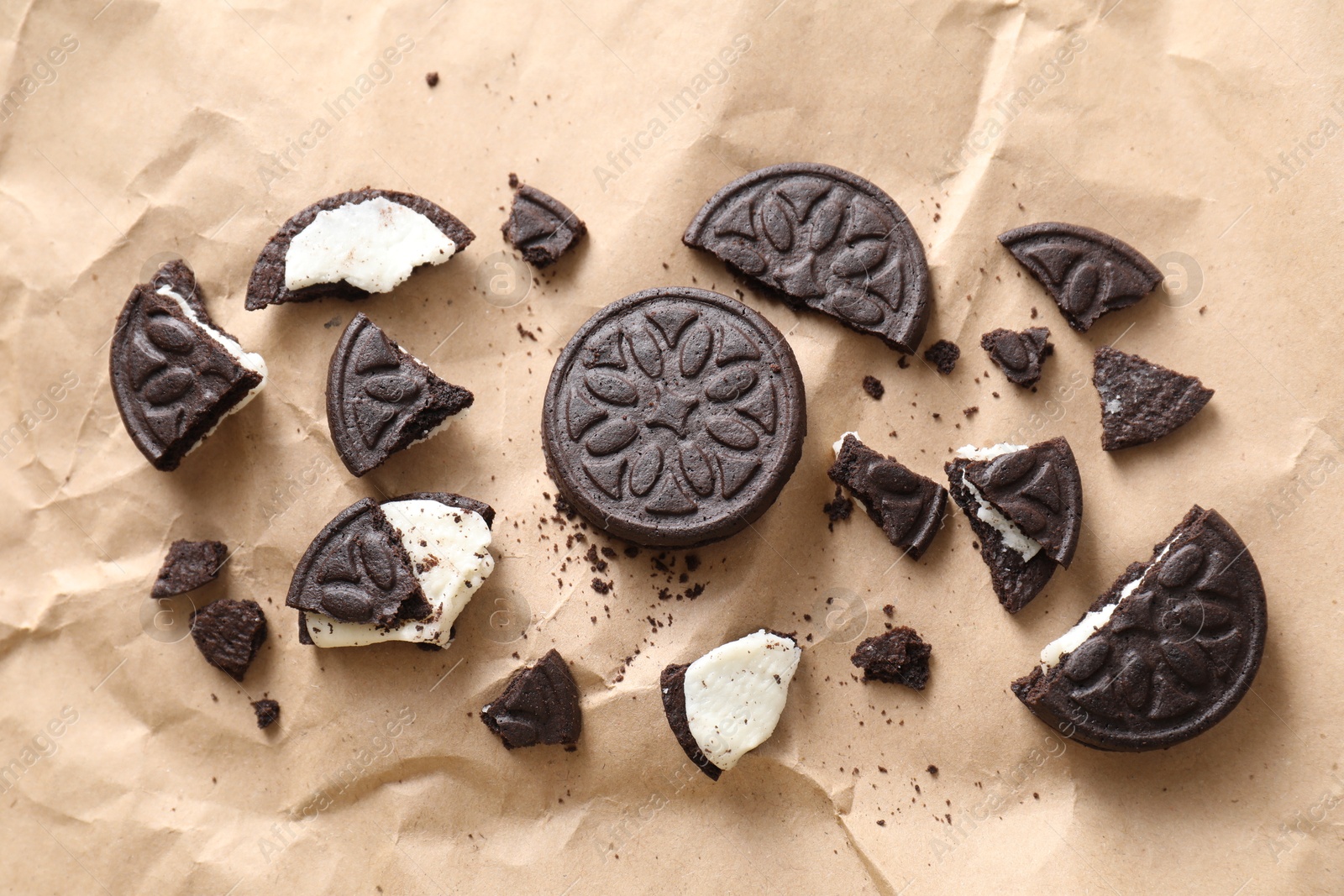 Photo of Tasty sandwich cookies on parchment paper, flat lay