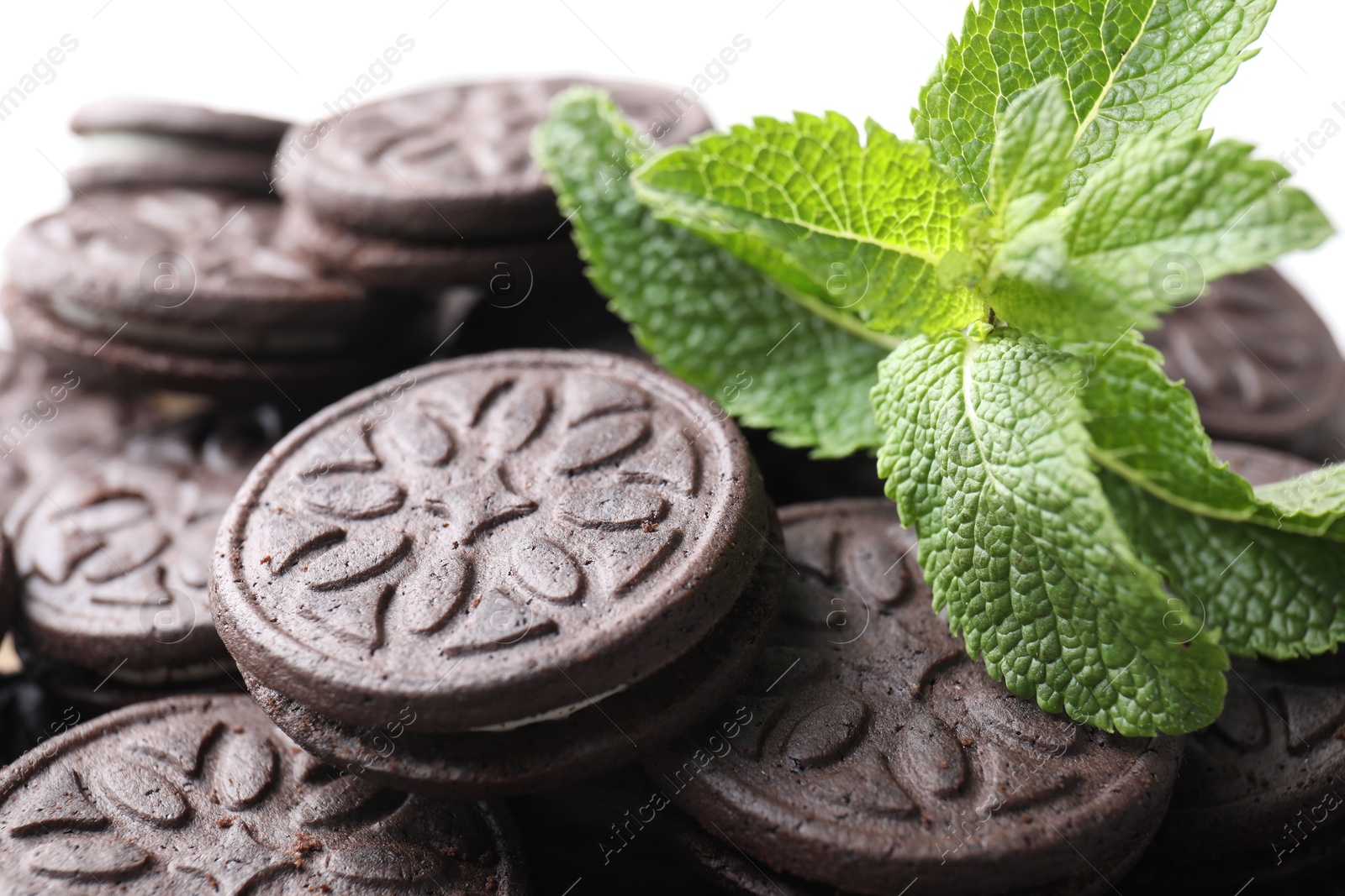 Photo of Tasty sandwich cookies and mint leaves, closeup