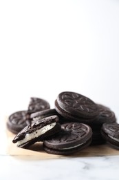 Photo of Tasty sandwich cookies on white marble table. Space for text