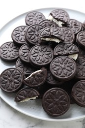 Photo of Tasty sandwich cookies on white marble table