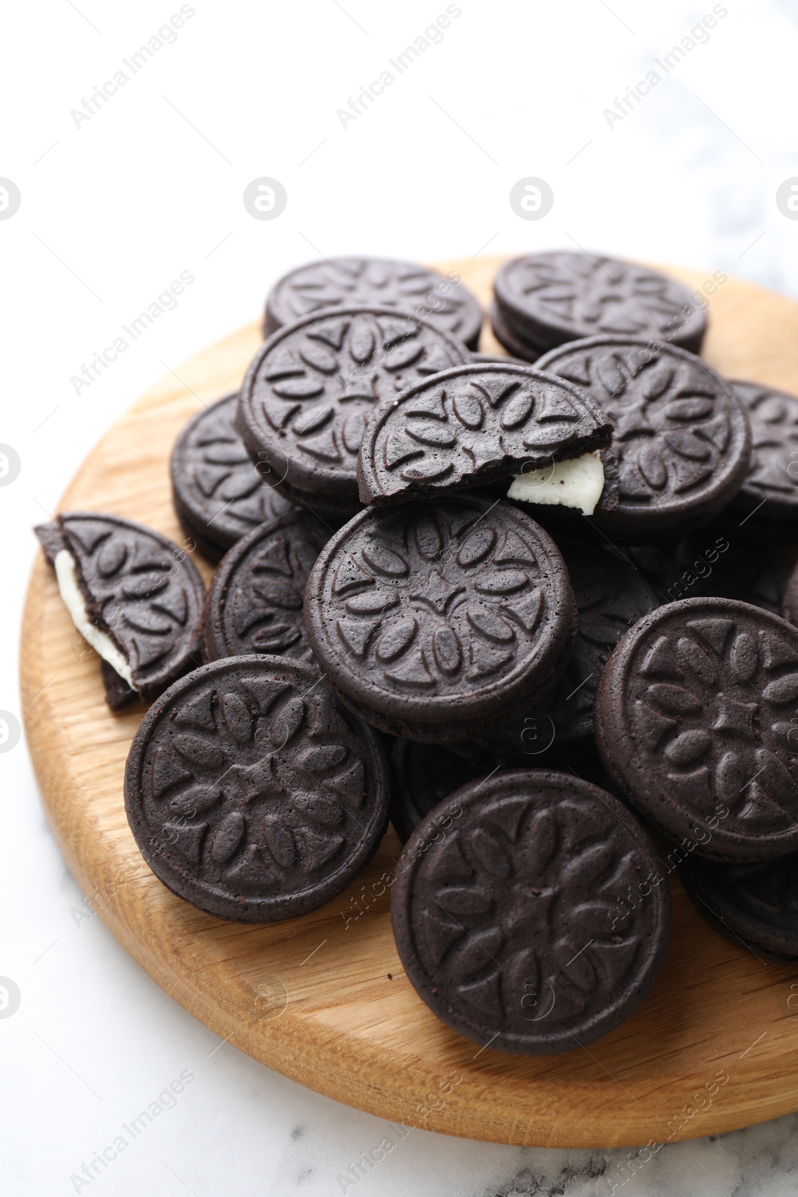 Photo of Tasty sandwich cookies on white marble table