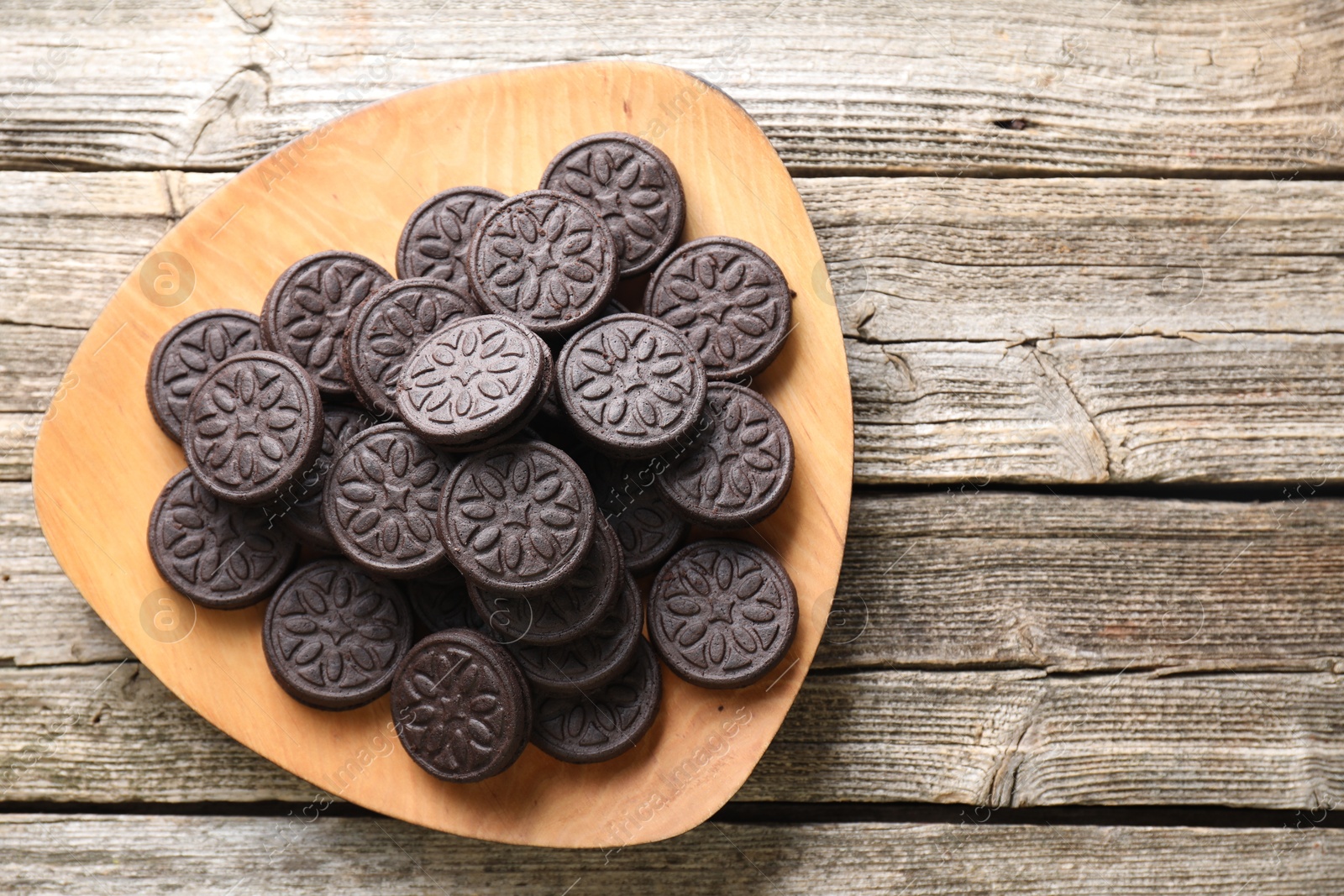 Photo of Many tasty sandwich cookies on wooden table, top view. Space for text