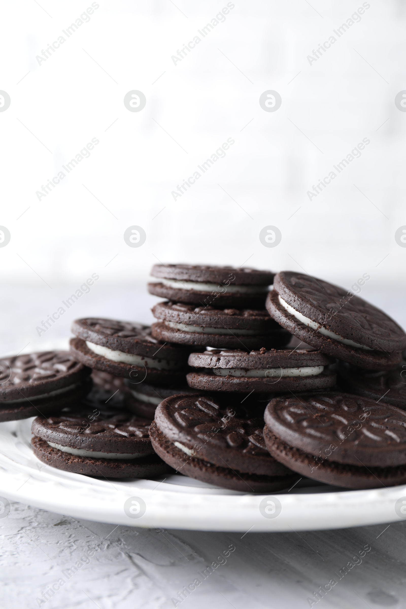 Photo of Many tasty sandwich cookies on light grey table