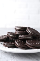 Many tasty sandwich cookies on light grey table