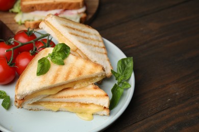 Photo of Pieces of toasted bread with melted cheese served on wooden table, space for text