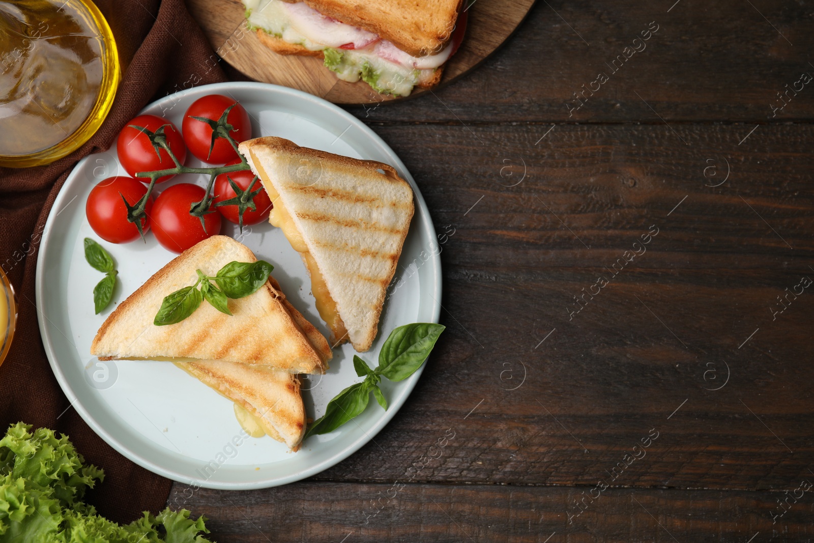 Photo of Pieces of toasted bread with melted cheese served on wooden table, top view. Space for text