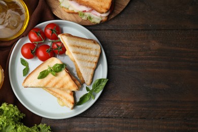 Photo of Pieces of toasted bread with melted cheese served on wooden table, top view. Space for text