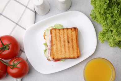 Photo of Tasty toasted bread with melted cheese, tomatoes, lettuce and juice on light table, top view