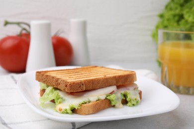 Photo of Tasty toasted bread with melted cheese and lettuce on table