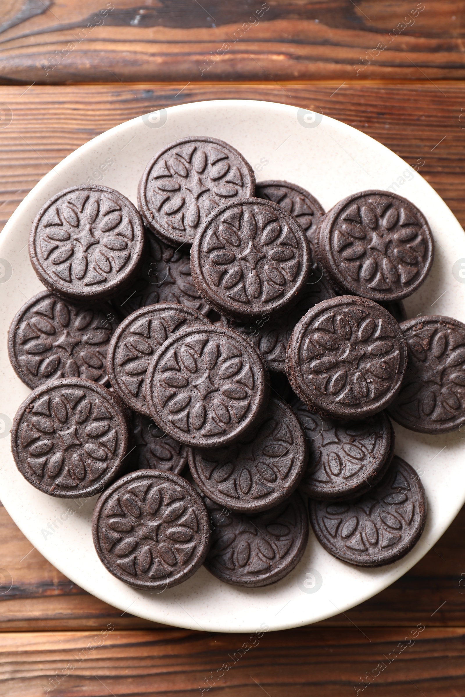 Photo of Many tasty sandwich cookies on wooden table, top view