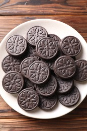 Many tasty sandwich cookies on wooden table, top view