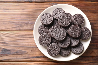 Photo of Many tasty sandwich cookies on wooden table, top view. Space for text