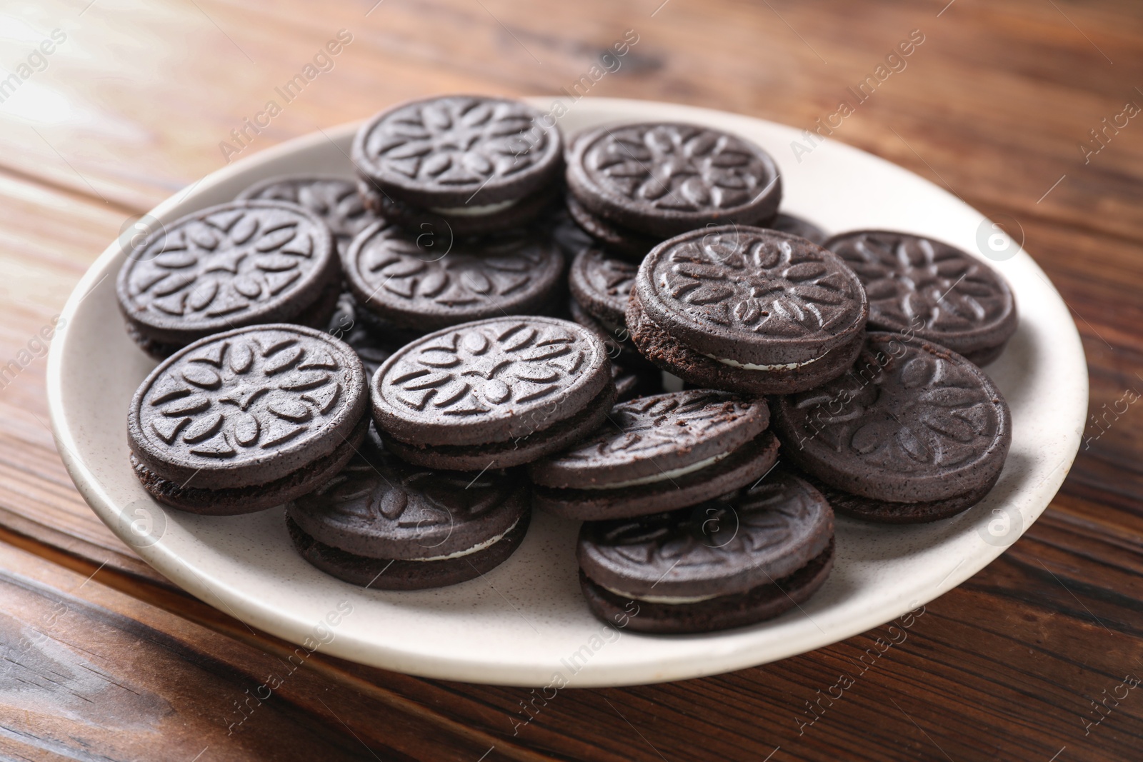 Photo of Many tasty sandwich cookies on wooden table