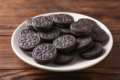 Many tasty sandwich cookies on wooden table