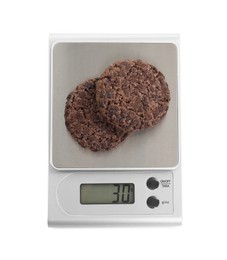 Kitchen scale with chocolate cookies isolated on white, top view