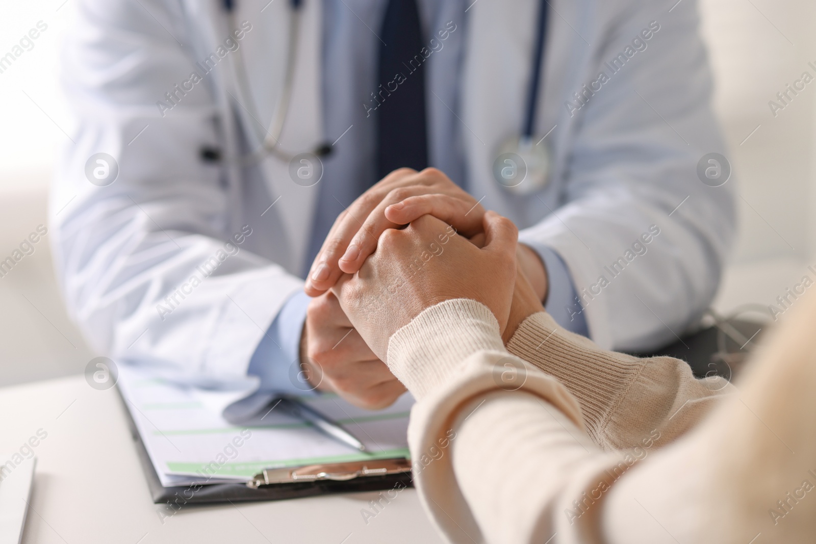 Photo of Professional doctor working with patient at white table in hospital, closeup