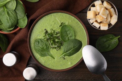 Photo of Delicious spinach cream soup served on wooden table, flat lay