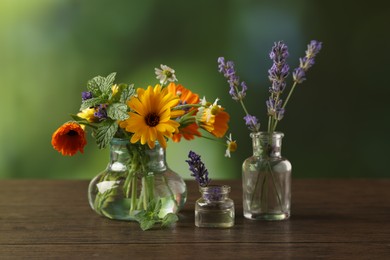 Different flowers in glass bottles on wooden table