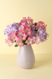 Photo of Beautiful alstroemeria flowers in vase on beige background