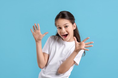 Portrait of emotional girl on light blue background