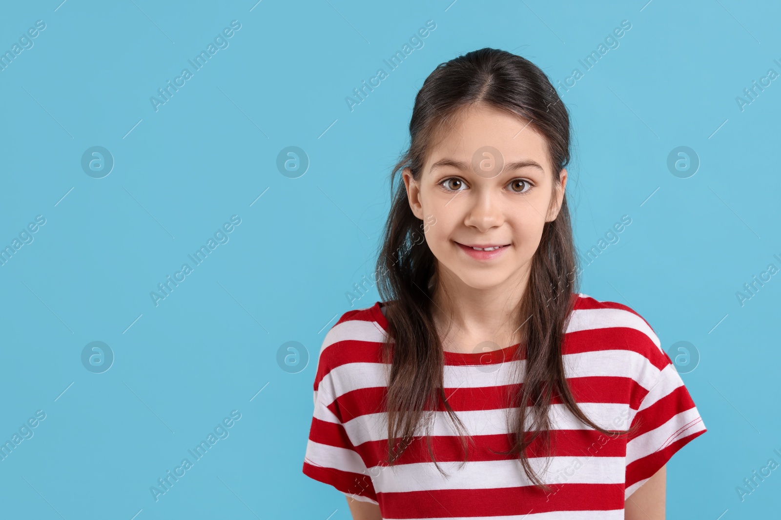 Photo of Portrait of beautiful girl on light blue background, space for text