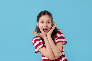 Portrait of emotional girl on light blue background