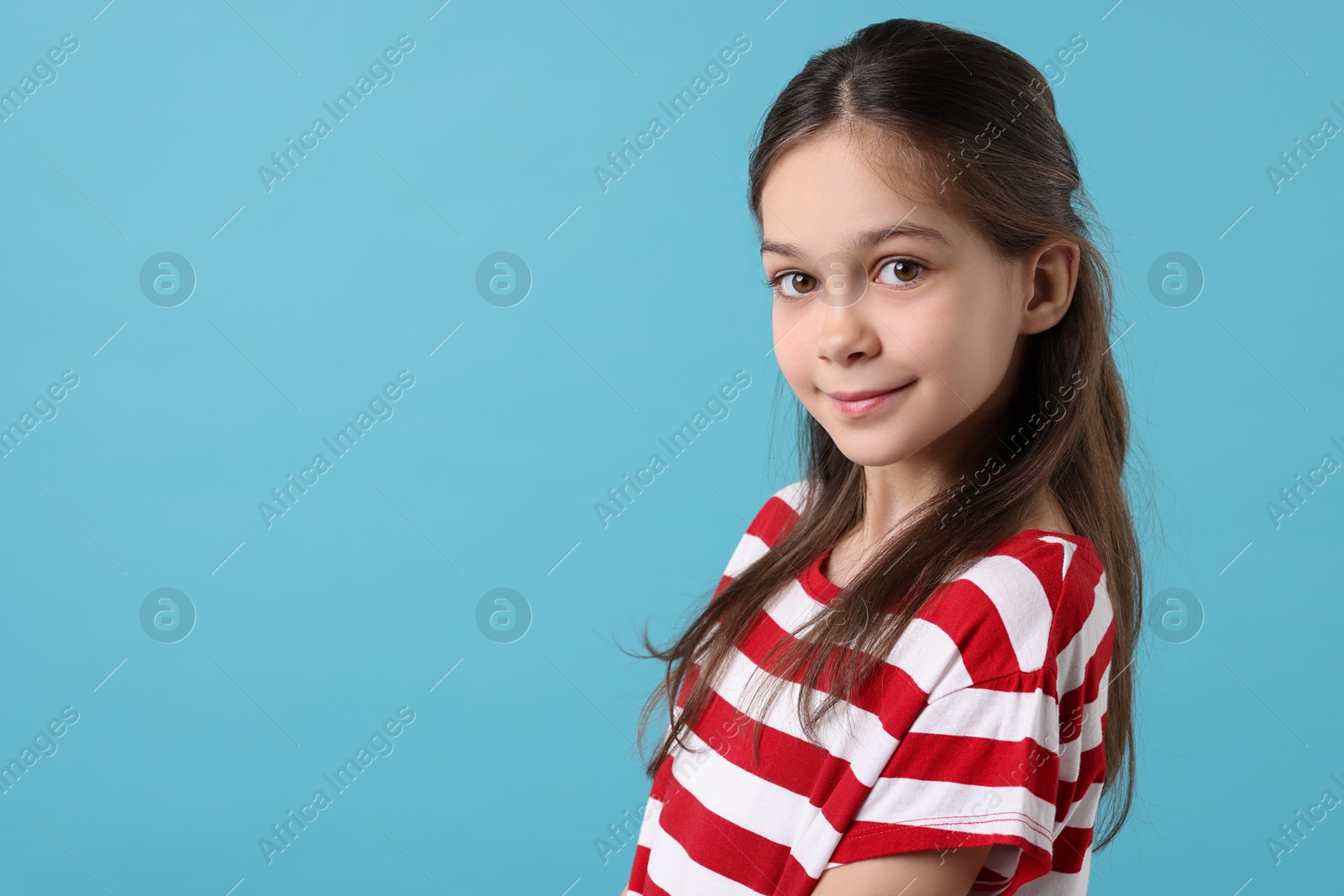 Photo of Portrait of beautiful girl on light blue background, space for text