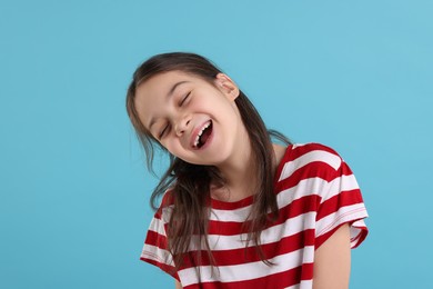 Photo of Portrait of happy girl on light blue background