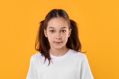 Portrait of beautiful girl on orange background