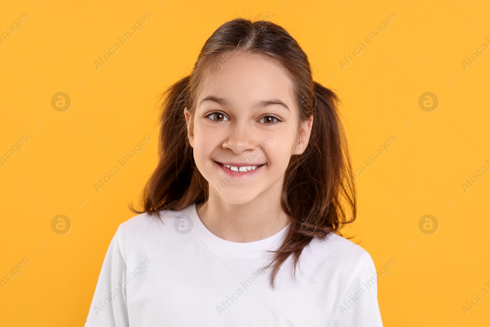 Photo of Portrait of happy girl on orange background