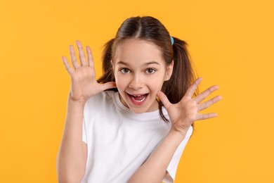 Portrait of emotional girl on orange background