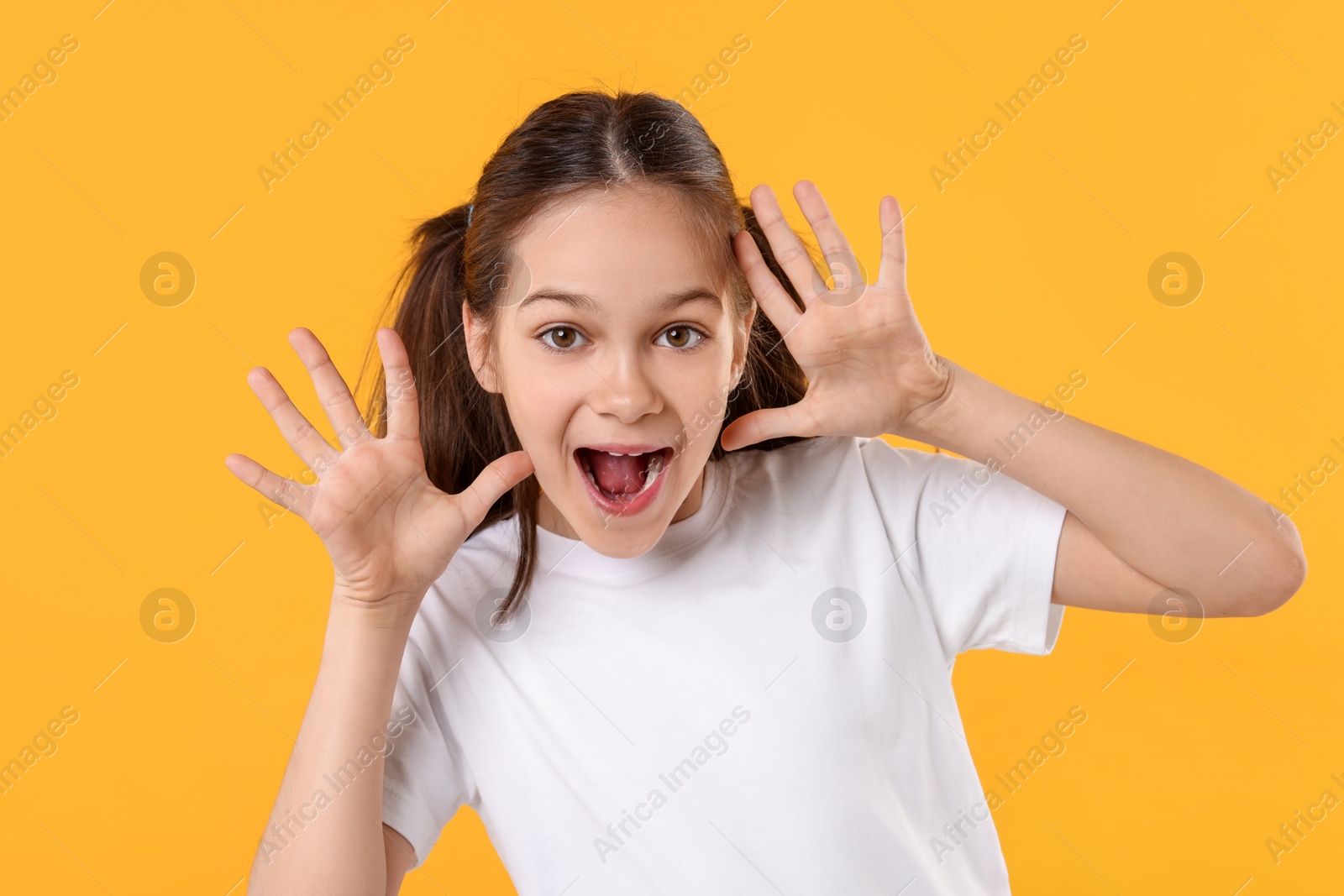 Photo of Portrait of emotional girl on orange background