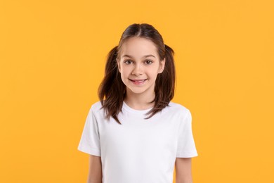 Portrait of beautiful girl on orange background