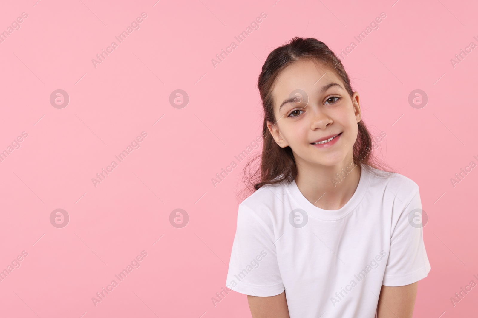 Photo of Portrait of happy girl on pink background, space for text