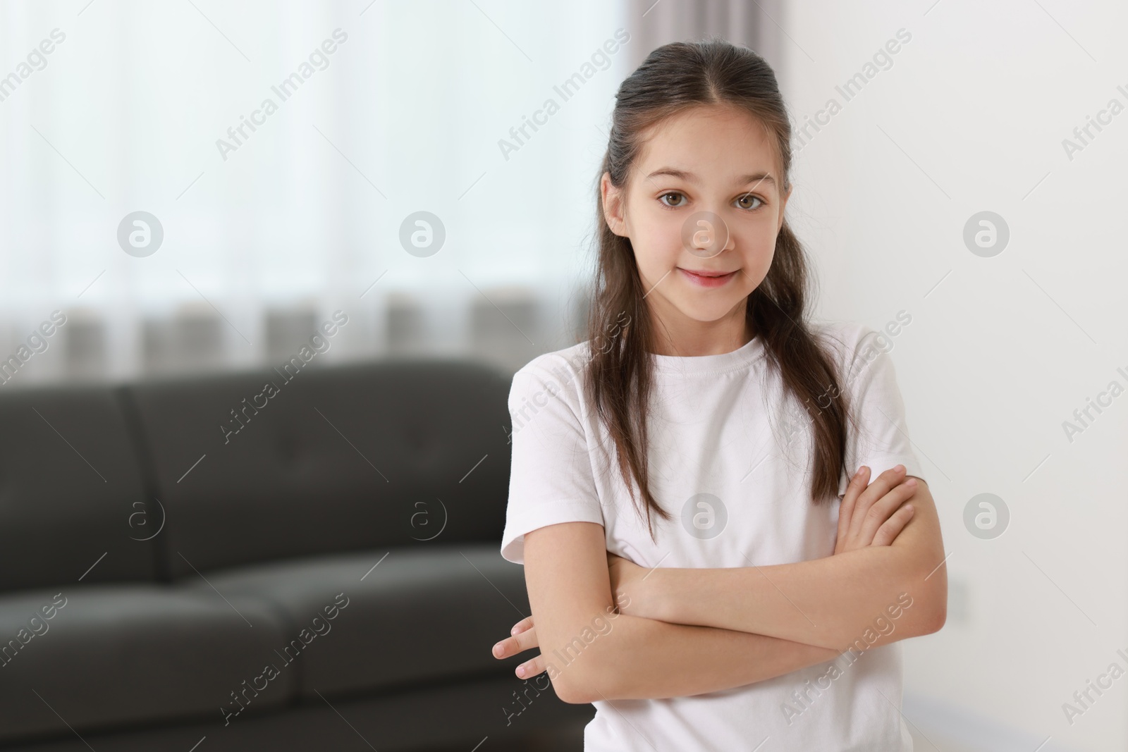 Photo of Portrait of cute little girl indoors, space for text