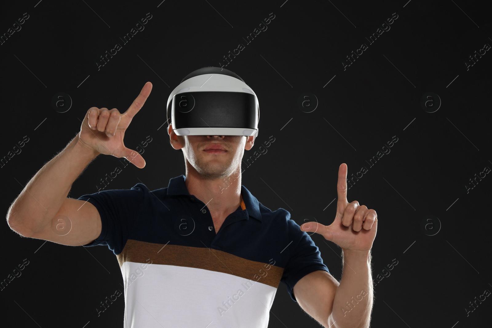 Photo of Man using virtual reality headset on black background