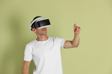Man using virtual reality headset on light green background