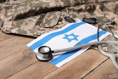 Stethoscope, flag of Israel, tags and military uniform on wooden table, closeup