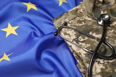 Stethoscope and military uniform on flag of European Union, closeup