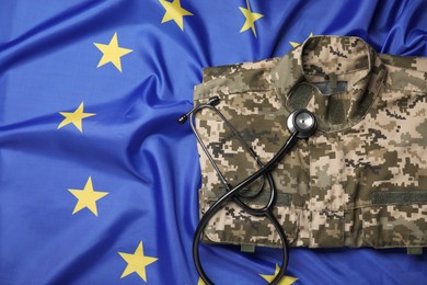 Photo of Stethoscope and military uniform on flag of European Union, top view