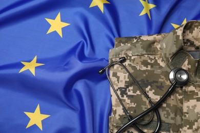 Photo of Stethoscope and military uniform on flag of European Union, top view